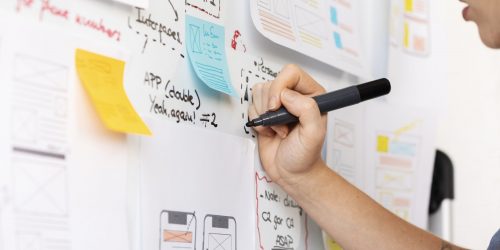 disenadora web femenina con papeles y notas en la oficina