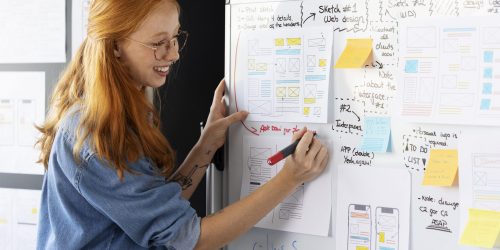 disenadora web femenina con papeles y notas en la oficina(1)