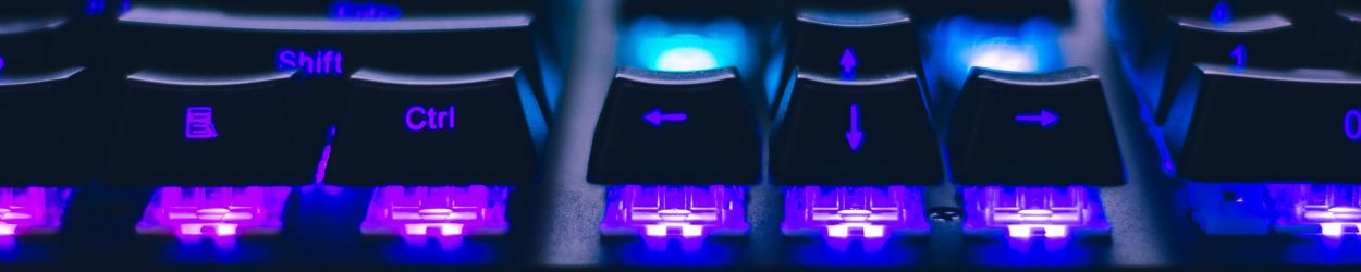 A detailed close-up of illuminated mechanical keyboard keys with focus on blue and purple lights.